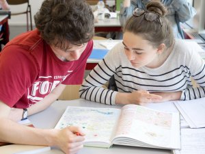 Docent helpt leerling examentraining aardrijkskunde SSL