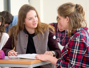 Docent helpt een leerling bij de eindexamentraining van SSL Leiden.