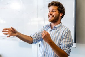Student die bijles geeft aan een leerlingen in de klas