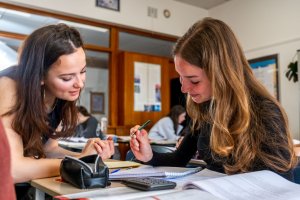 Assistent-docent ondersteunt leerling tijdens studiebegeleiding