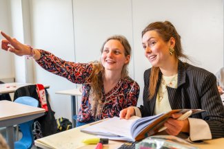 Docent van SSL helpt een leerling en wijst naar het bord